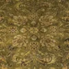 Macro shot of the dense hand-knotted wool pile showing intricate sage green and tan floral motifs on a bright golden-yellow background.