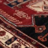 Macro shot of the dense hand-knotted wool pile on an Iranian Kuliai rug showing bold geometric tribal motifs and vibrant vegetable dyes.