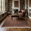 Sophisticated home library with floor-to-ceiling bookshelves and dark wood floors, featuring a 6' 3" x 8' 1" coral Pakistan Bokhara rug.