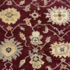 Macro shot of the hand-spun wool pile on a burgundy Chobi rug showing detailed ivory and sage floral motifs and natural color variations.