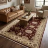Elegant living room with a brown tufted leather sofa and dark wood floors, featuring a 6' x 9' burgundy and ivory Chobi wool rug.