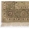 Detailed corner view of a sage Chobi rug showing the wide ornate botanical border and clean white hand-bound fringe.