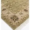 Detailed corner view of a sage Chobi rug showing the wide ornate ivory-tan botanical border and clean white hand-bound fringe.