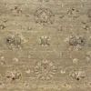 Macro shot of the hand-spun wool pile on a sage Chobi rug showing detailed ivory floral motifs and natural abrash color variations.