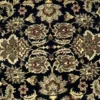 Macro shot of the dense hand-knotted wool pile showing mirrored sage green and tan floral palmettes on a black background.