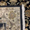 Close-up view of the underside of an Indian wool rug, showing the visible individual hand-tied knots and authentic textile construction.