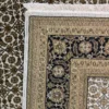 Close-up view of the underside of an Indian wool rug, showing the visible individual hand-tied knots and authentic textile construction.