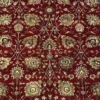 Macro shot of the dense hand-knotted wool pile showing intricate gold and tan floral motifs on a saturated ruby red background.