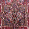 Macro shot of the dense hand-knotted wool pile on a Heriz rug showing the intricate geometric central star and saturated vegetable-dye colors.