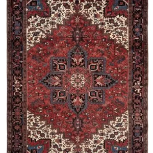 Full overhead view of an 8' 2" x 11' 5" hand-knotted Persian Heriz wool rug featuring a bold geometric central medallion on a rich red field with navy blue corners.