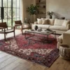Expansive contemporary living room with a neutral sofa and light wood floors, anchored by a large red and indigo Persian Heriz rug.