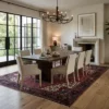Modern formal dining room with a long oak table and minimalist chairs, featuring an 8x11 Persian Heriz rug as a prestigious focal point.