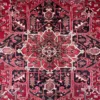 Macro shot of the dense hand-knotted wool pile on a Heriz rug showing the sharp geometric central star and saturated vegetable-dye colors.