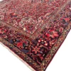 Angled low-profile view of a large Heriz wool rug showing the luminous wool luster and intricate all-over geometric pattern.