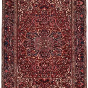 Full overhead view of an 8' 6" x 11' 7" hand-knotted Persian Heriz wool rug featuring a large geometric central medallion on a rich red field.