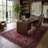 Professional home office with full-height walnut bookshelves and a modern desk, anchored by a large red Persian Heriz rug.