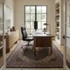 Professional home office with a walnut desk, leather chair, and built-in bookshelves, anchored by a dark charcoal and bronze Indian wool rug.
