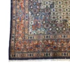 Close-up corner view of a Persian Birjand rug highlighting the dense floral border, rich terracotta spandrels, and tightly bound selvedge.