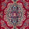 Macro shot of the dense hand-knotted wool pile on a Darbari rug showing the central floral medallion with intricate navy, ivory, and sky-blue details.