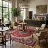 Modern upscale cafe and library with a dark wood bar and seating areas, anchored by a large red Iran Darbari wool rug under a modern chandelier.
