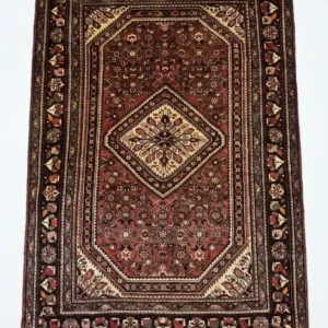 Full overhead view of a 6' 10" x 10' 4" hand-knotted Iranian Hosinabad wool rug with a sharp cream and red central diamond medallion.