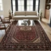 Luminous contemporary living room featuring a beige sofa and glass coffee table, anchored by a 7x10 red and charcoal Hosinabad Persian rug.