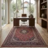 Professional home workspace with a walnut desk and leather chair, centered over an intricate red Kashan Persian wool rug.
