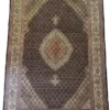 Full overhead view of a 4' 7" x 9' 11" hand-knotted Iranian Mahi wool rug featuring a repeating geometric fish pattern in dark brown and ivory white.