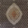 Macro shot of the high-density hand-knotted wool pile on an Iranian Mahi rug showing the intricate brown and white repeating leaf and fish motifs.