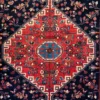 Close-up macro shot of the high-luster wool pile on a Nahavand rug highlighting the sharp geometric lines of the red diamond medallion and blue core.