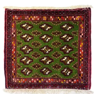 Overhead view of a 1' 10" x 1' 8" hand-knotted Iranian Persian wool rug featuring a vibrant green field with repeating tribal motifs and a deep red geometric border.