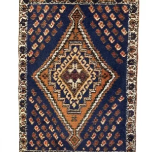 Overhead view of a 1' 7" x 2' 3" hand-knotted Iranian Qashqai wool rug featuring a deep navy field with three geometric medallions and burnt orange accents.