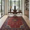 Professional home workspace with a walnut desk and brown leather chair, centered over an intricate 7x10 cherry-red Sarough Persian wool rug.
