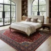 Peaceful primary bedroom with a mid-century walnut bed frame and beige linens, anchored by an intricate red Sarough Persian rug under arched windows.