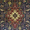 Macro shot of the dense hand-knotted wool pile on an Iranian Tabriz rug, showing the highly precise geometric floral paths and warm neutral tones.