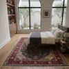 Peaceful master bedroom featuring a walnut bed frame and beige linens, anchored by a traditional camel and terracotta Tabriz Persian rug on light hardwood floors.