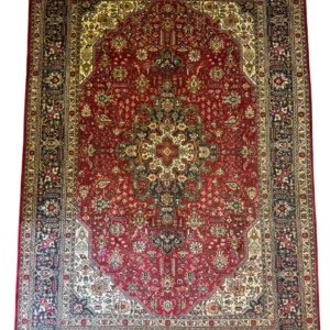 Full overhead view of a 6' 6" x 9' 10" hand-knotted Iranian Tabriz wool rug with a complex center medallion on a rich crimson field with navy borders.