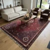 Luminous contemporary living room with a cream sofa and walnut coffee table, anchored by a 6x10 plum and deep red Iranian wool area rug.