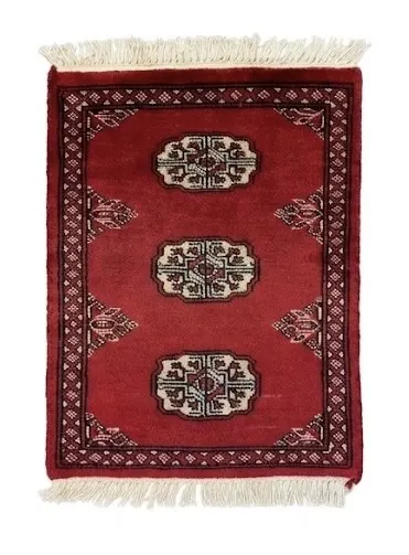 Overhead view of a 1' 6" x 1' 11" hand-knotted Pakistan Bokhara wool rug featuring a deep red field and three central ivory gul medallions.