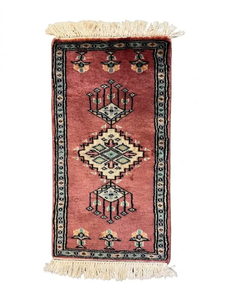 Overhead view of a 1' 0" x 2' 0" hand-knotted Pakistan Jaldar wool rug featuring a rose-terracotta field with three geometric diamond medallions.