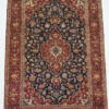 Full overhead view of a 6' 6" x 9' 10" hand-knotted Iranian Kashan wool rug featuring an ornate central medallion on a midnight navy field with red floral borders.