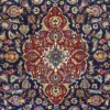 Close-up macro shot of the high-density hand-knotted wool pile on an Iranian Kashan rug, highlighting the fine curvilinear floral patterns and rich red and navy colors.