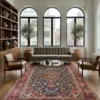 Luminous contemporary living room with a taupe sofa and glass coffee table, anchored by a 6x10 red and navy Kashan Persian rug on light wood floors.