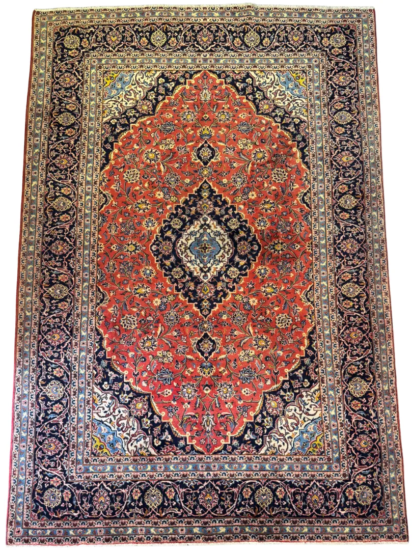 Full overhead view of a 6' 6" x 9' 10" hand-knotted Iranian Kashan wool rug featuring a large center diamond medallion on a rich red field with navy blue borders.