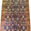Full top-down overview of a 7' 2" x 10' 9" hand-knotted Iranian Khalkhal wool rug with an all-over floral layout on a deep midnight blue field with golden-yellow borders.