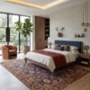 High-end primary bedroom suite with a walnut platform bed and rust throw blanket, grounded by a blue and gold Khalkhal wool rug.
