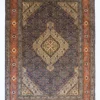 Full overhead view of a 6' 6" x 9' 10" hand-knotted Iranian Mahi wool rug with a detailed central diamond medallion on a midnight blue, burnt orange, and amber yellow repeating fish pattern field.