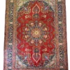 Full overhead view of a 6' 6" x 9' 6" hand-knotted Iranian Sabzevar wool rug featuring a large circular floral medallion on a vibrant red field with navy blue borders.