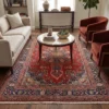 Modern formal living room with a cream sofa and terracotta armchairs, anchored by a 6x10 red Sabzevar Persian area rug on light wood floors.