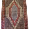 Full overhead view of a 6' 7" x 9' 10" hand-knotted Iranian Seneh wool rug featuring a large stepped diamond medallion in slate blue, red, and cream on a dark field.
